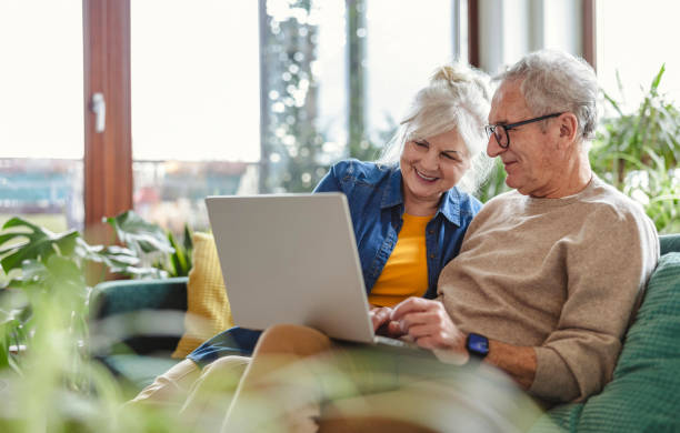 Senior couple researching Medicare on a laptop together